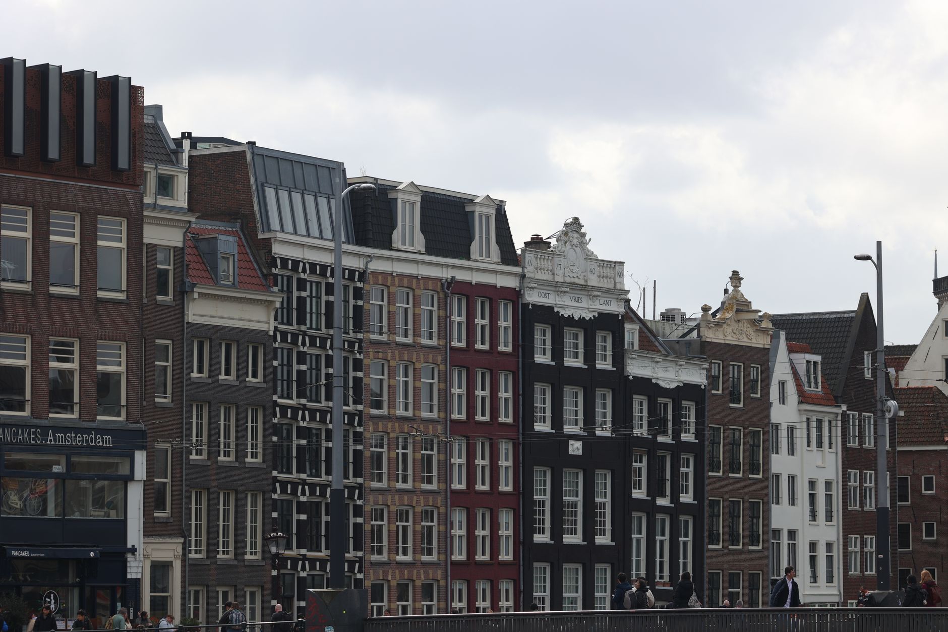 Vista panorámica de los canales históricos de Ámsterdam con edificios modernos al fondo.