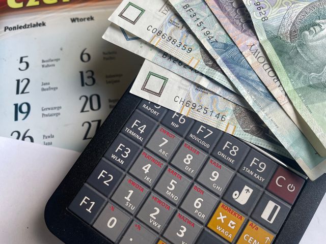 Manos sosteniendo un calendario con fechas de pago resaltadas, en un ambiente hogareño.