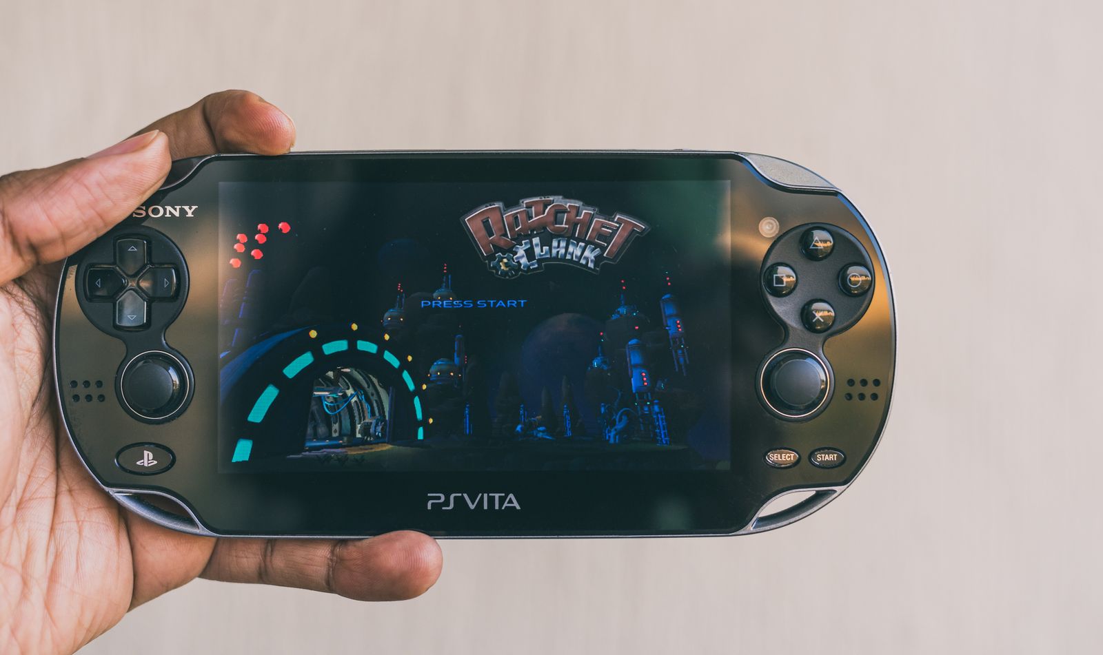 A person playing with the PlayStation Portal on the couch while another person watches TV.