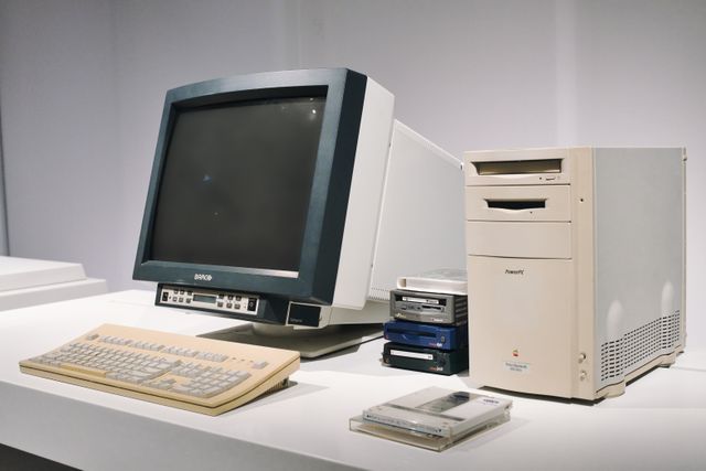 Periodista trabajando en una computadora de escritorio con monitor CRT en los años 90.