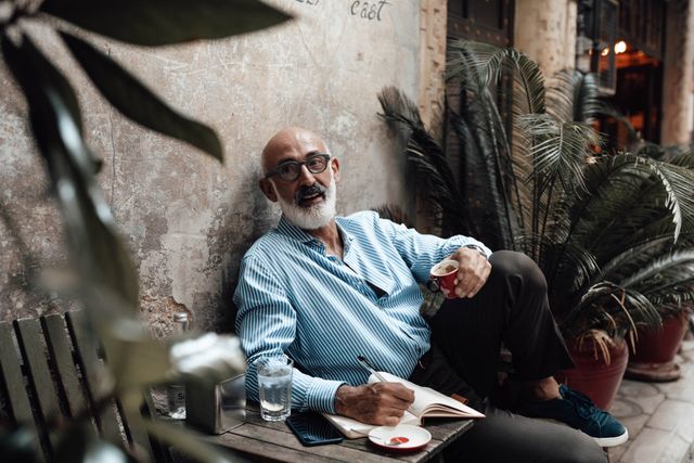 Eliseo Alberto sonriendo en un estudio lleno de libros.