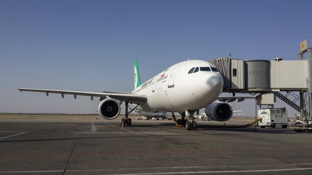 Un avión de pasajeros con la bandera iraní en la cola, estacionado en una pista de aeropuerto.