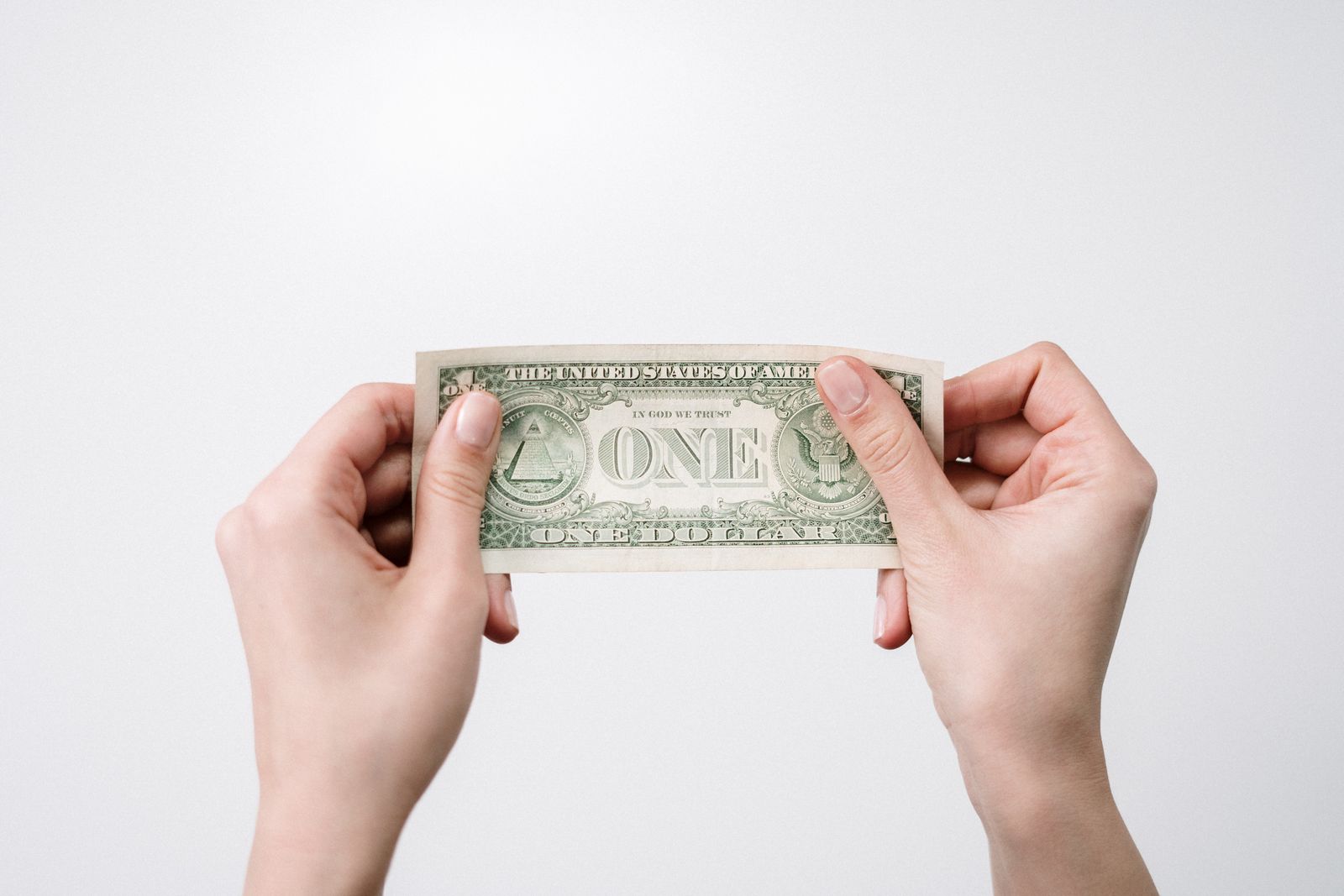 Hands holding Guatemalan Quetzal banknotes and US dollar bills, with a currency exchange screen in the background.