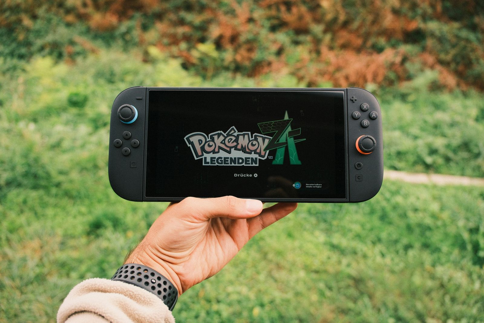Hands holding a video game controller in front of a screen with a subtle graph, illustrating subscription cancellations due to cost.