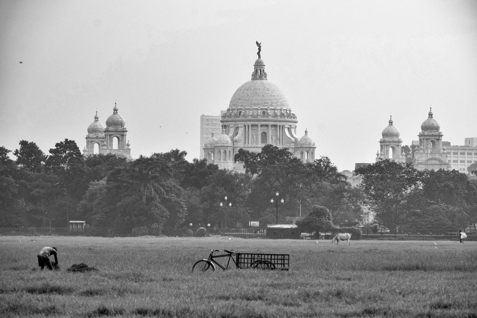 Bustling street in early 20th-century Calcutta, featuring colonial buildings and people of the era.
