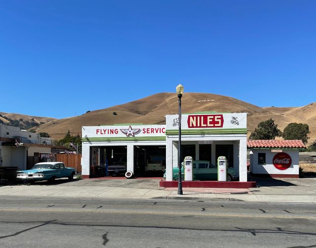 Un auto clásico estacionado en una carretera de California con un paisaje de fondo.