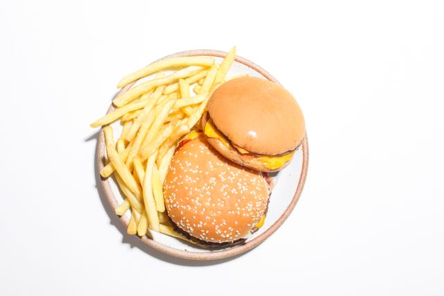 Una doble hamburguesa con queso recién hecha, con lechuga y tomate, en un ambiente de restaurante de comida rápida.