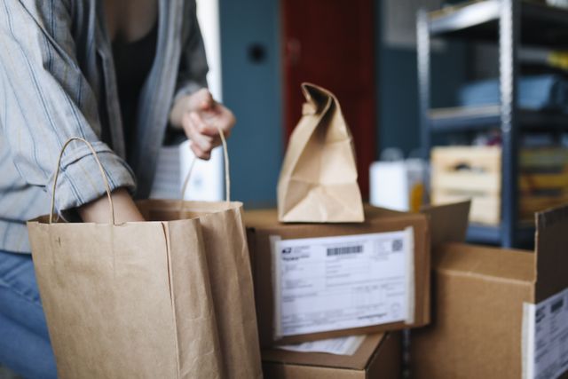 Una persona revisa ofertas en su laptop en un sofá, con una caja de Amazon cerca, después de los Prime Big Deal Days.