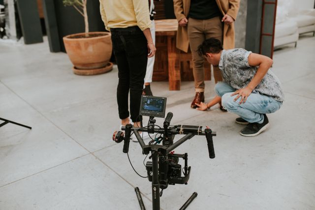 Miembros de un equipo de filmación trabajando en un set al aire libre, revisando una toma en un monitor.